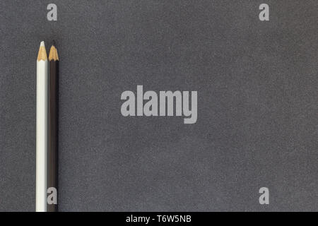 White and black colored pencils on dark background top view Stock Photo