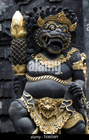 Gilded Guardian gate statue at the entrance to the Indonesian temple of Tanah Lot Stock Photo