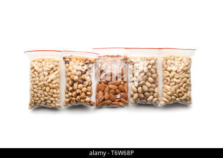 Different types of nuts in packages on white background Stock Photo