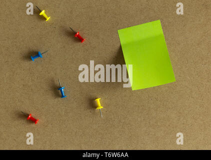Sticky blank sheet of paper notes with push pins on wooden board Stock Photo