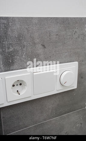 Light switch on the gray textured wall, light switch concrete wall Stock Photo
