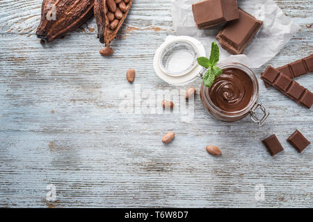 Composition with tasty melted chocolate on wooden background Stock Photo