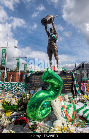 GLASGOW, SCOTLAND - 2nd May 2019: The statue of the Celtic icon, Billy McNeill, surrounded by scarves and shirts Stock Photo