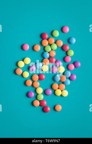 Colorful chocolate candy pills on blue background. Stock Photo