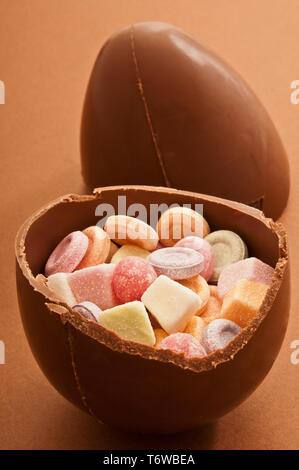 traditional Easter chocolate egg broken in half and filled with candies Stock Photo