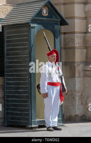 A historic re-enactment enthusiast in Napoleonic uniform stands guard at a green guard box outside the Grandmaster Palace in Republic Square, Valletta Stock Photo