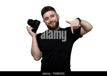 smiling bearded photographer, holding a camera and pointing down, isolated on white background, Stock Photo