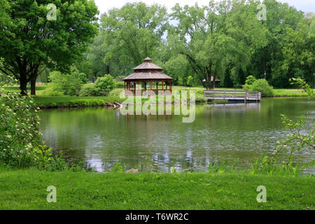 Beautiful late spring landscape with trees around the pond and wooden gazebo in a city park. Lakeview park, Middleton, Madison area, WI, USA. Stock Photo