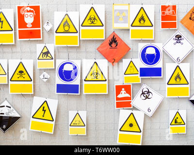 Many different danger signs on a wall, copy space Stock Photo