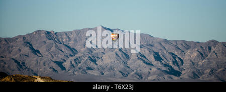 hot air balloon flying above red rock canyon Stock Photo