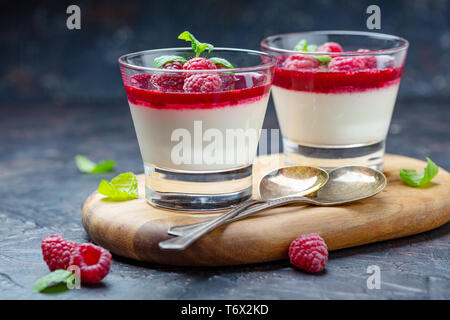 Panna cotta with berry sauce, raspberries and fresh mint. Stock Photo