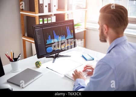 Close-up Of A Businessman's Hand Analyzing Graph On Laptop Stock Photo