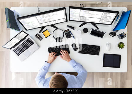 Computer programmer writing program code on computer in office Stock Photo