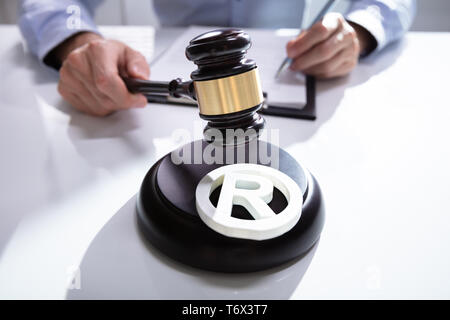 Close-up Of Judge Striking Mallet On Trademark Copyright Symbol Stock Photo