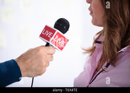 News Reporter Asking Questions To Young Businesswoman In Office Stock Photo