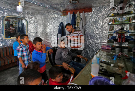 Anjar, Lebanon. 03rd May, 2019. A Syrian refugee barber cuts the hair of a boy at his make-shift barber tent at a refugee camp. Credit: Marwan Naamani/dpa/Alamy Live News Stock Photo