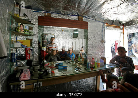 Anjar, Lebanon. 03rd May, 2019. A Syrian refugee barber cuts the hair of a boy at his make-shift barber tent at a refugee camp. Credit: Marwan Naamani/dpa/Alamy Live News Stock Photo