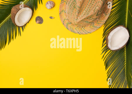 hat, coconuts and palm leaves isolated on yellow background, top view Stock Photo