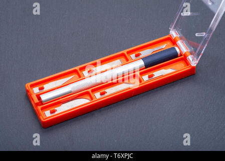 Hobby Knife Set for cutting wood, paper, plastic and cloth on gray stone background. Stock Photo