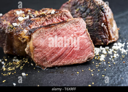 Barbecue wagyu roast beef sliced as top view on a black board Stock Photo