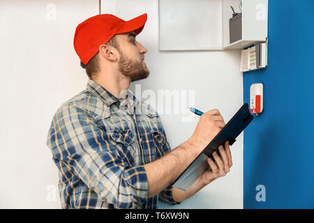 Young electrician installing alarm system Stock Photo