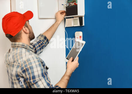 Young electrician installing alarm system Stock Photo