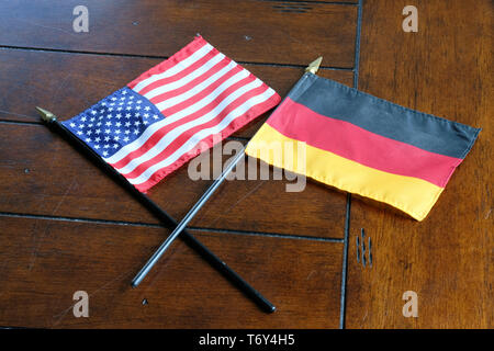 Flags of the United States and Germany on a wooden surface; German American relations. Stock Photo