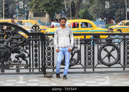 young man model standing infront of a gate with busy road background Stock Photo
