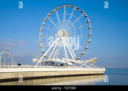 Tourist attraction - a ferris wheel on the shore of the Caspian Sea on a sunny December afternoon. Baku, Azerbaijan Stock Photo