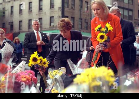 First Lady Laura W Bush and Libby Pataki, wife of New York Governor George Pataki, place sunflowers at a memorial at Battalion 9 Firehouse in New York City, honoring the firefighters who died at the World Trade Center, 2001. Courtesy National Archives. () Stock Photo