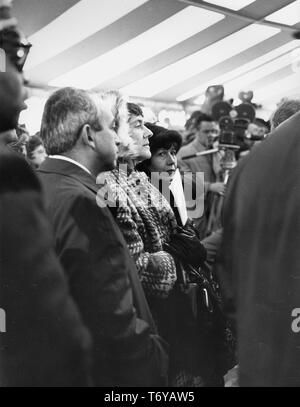 Close-up of a crowd of people (including from left to right, Ned Goldwasser, Deputy Director of Fermilab, Mrs Goldwasser, and Mrs Robert Wilson) participating in a Fermilab groundbreaking ceremony, Batavia, Illinois, December, 1968. Image courtesy US Department of Energy. () Stock Photo