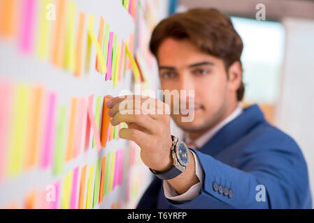 The young handsome man in conflicting priorities concept Stock Photo