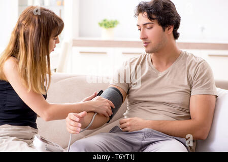 The wife checking husband's blood pressure Stock Photo