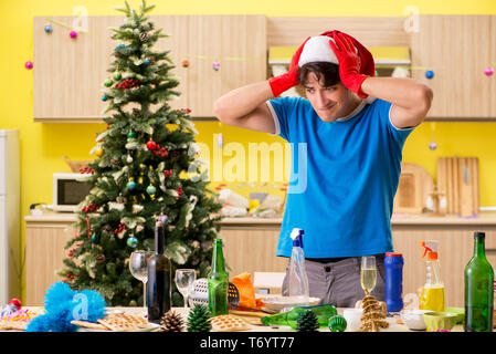 The young man cleaning kitchen after christmas party Stock Photo