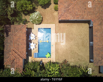 house backyard with swimming pool above drone view on sunny day Stock Photo