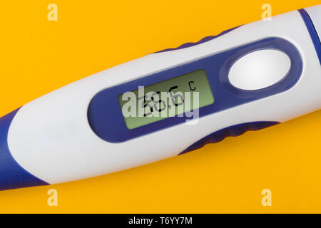 Electronic medical thermometer (36.6 degrees) on yellow background Stock Photo