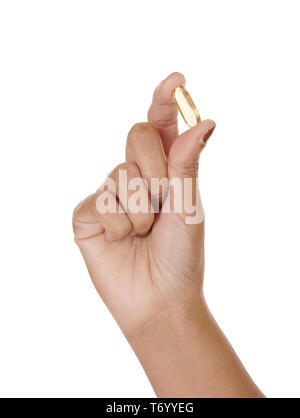 The hand of a woman holding a vitamin pill Stock Photo