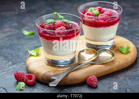 Vanilla Panna cotta with berry sauce and fresh raspberries. Stock Photo