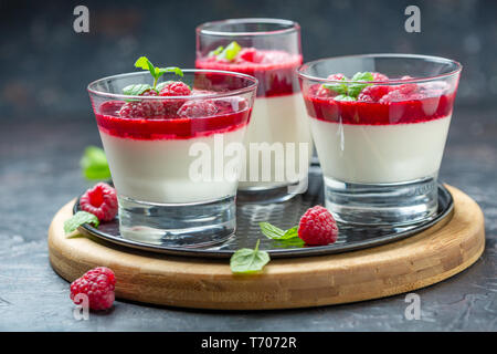 Panna cotta with berry sauce, raspberries and fresh mint. Stock Photo