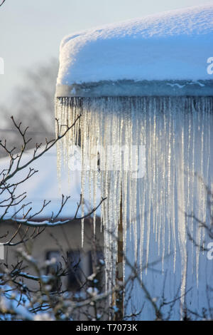 Roof with icicles hanging from roof. Stock Photo