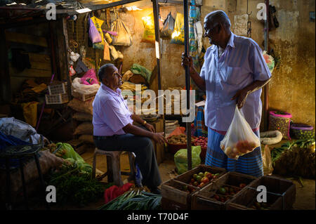 Two men talking business in Kandy Municipal Central Market, Kandy, Sri Lanka Stock Photo