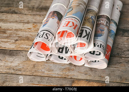 Rolled newspapers on wooden background Stock Photo