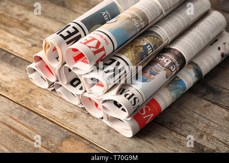 Rolled newspapers on wooden background Stock Photo