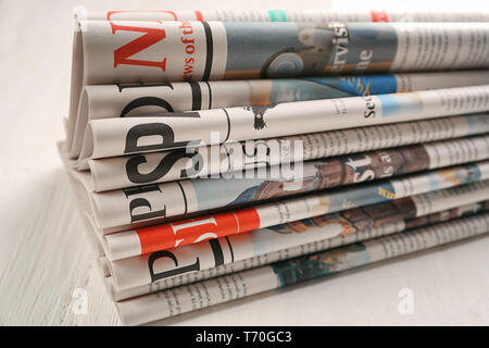 Newspapers on white wooden background Stock Photo