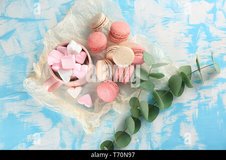 Flat lay composition with tasty macarons and marshmallows on table Stock Photo