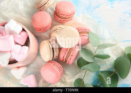 Flat lay composition with tasty macarons and marshmallows on table Stock Photo