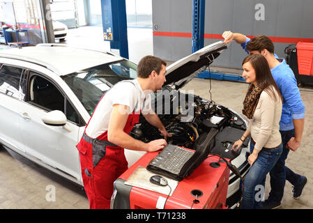 customer service in a garage - mechanic and customer discuss the repair of a vehicle Stock Photo