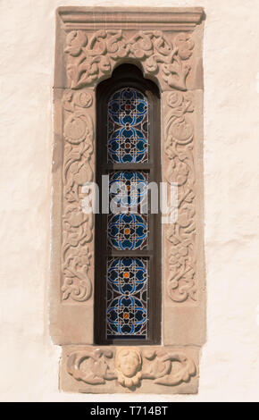 old, stone carved windows frame with stained glass motif Stock Photo