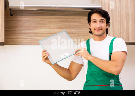 Young contractor repairing air-conditioner in kitchen Stock Photo