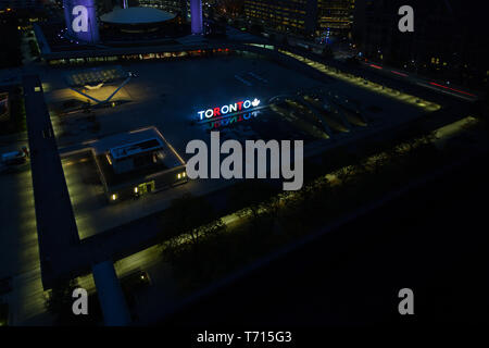 An aerial night time view across Nathan Phillips Square in Toronto, Canada.  The illuminated 3D Toronto sign can be seen. Stock Photo